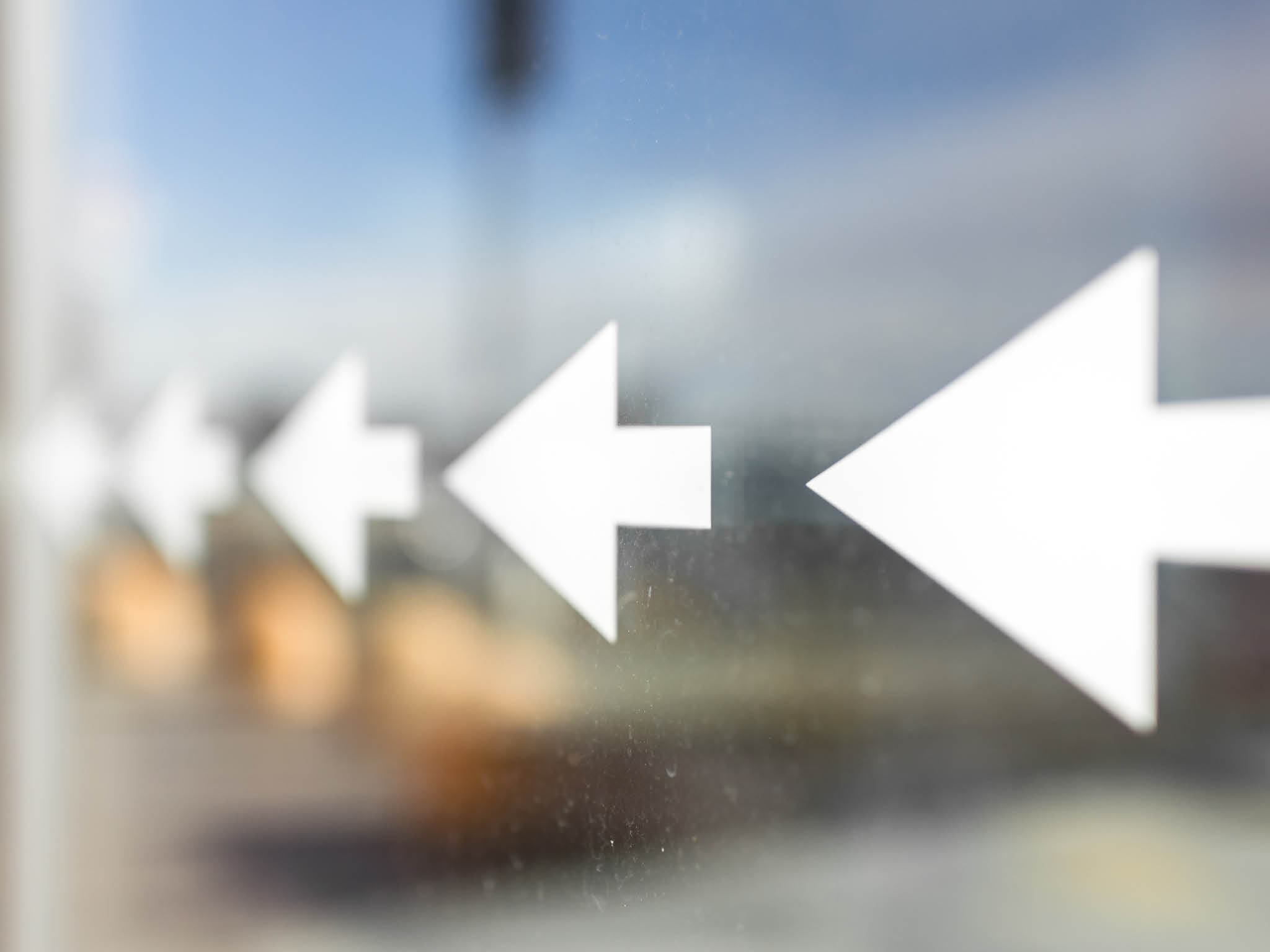 Long row of arrows stickers on a dirty window 