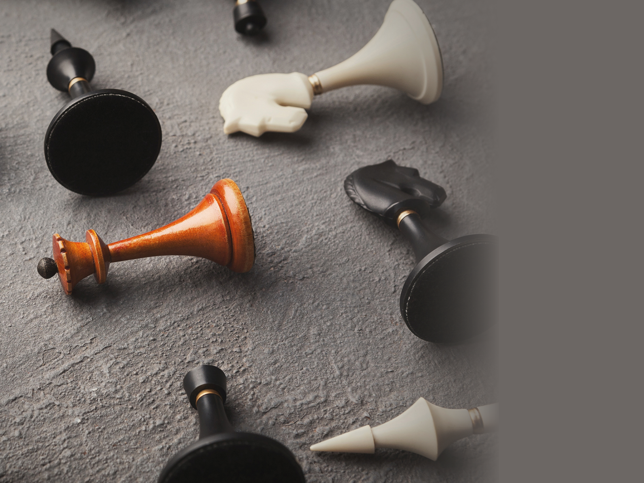 Wooden queen lying among other black and white chess set on beige background. Individuality and loneliness concept