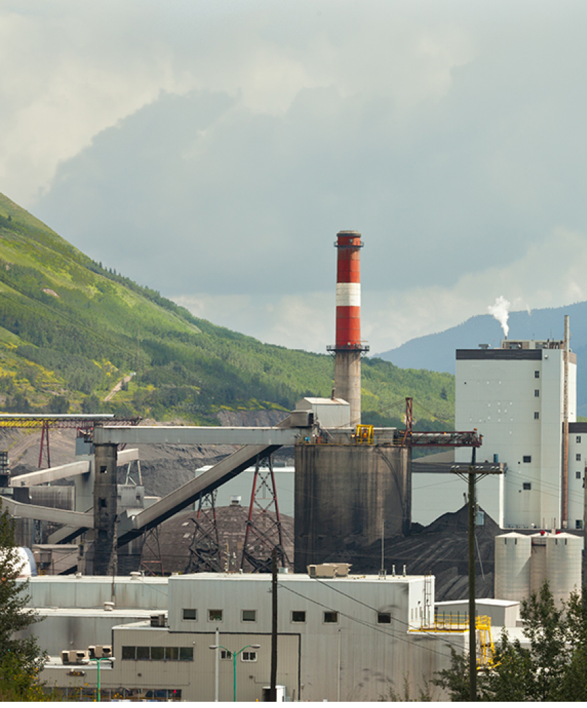Black coal mine pile at coal fired electric energy power station in green valley contributes to global warming