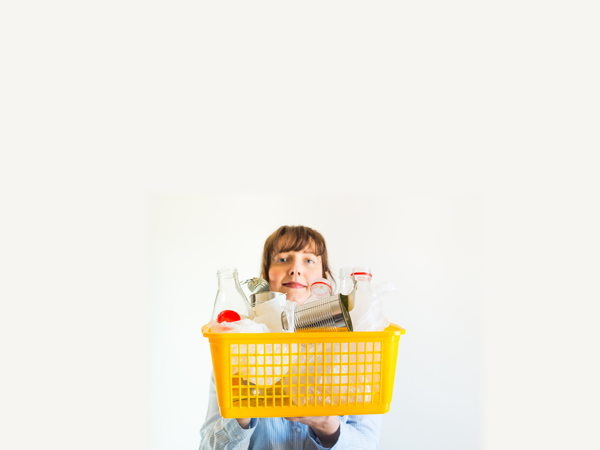 Caucasian woman on white background with trash ready for recycling - plastic bottles and bags, metal cans, glass bottles. We are responsible for our future.