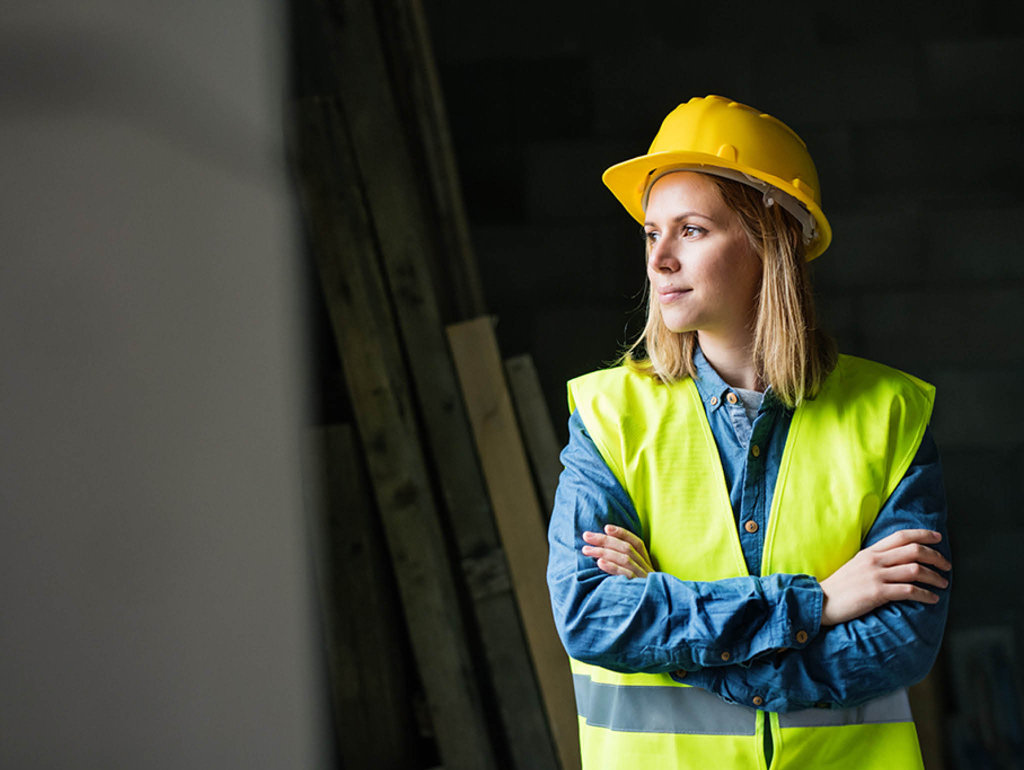Female worker on the construction site  Beautiful young woman with crossed arms 