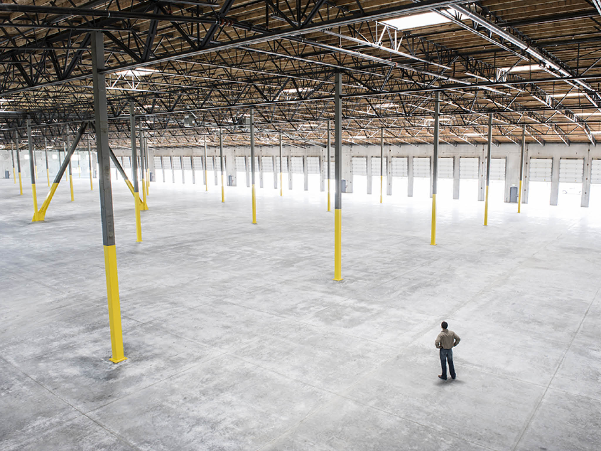 Owner checking out the new interior of a large empty warehouse space.